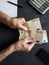 hands of an older man counting european banknotes