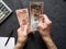 hands of an older man counting honduran banknotes