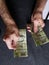 hands of an older man counting Mexican banknotes