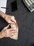 hands of an older man holding uruguayan banknotes