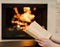 Hands with open book near the fireplace