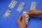 Hands opening packaging with pills across blue background and medicine capsules. Healthcare concept. Top view. Treatment.