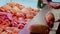 Hands of operators filling and forming sausages at food store