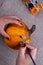 Hands paint a homemade papier mache pumpkin in orange for Halloween, a hobby for children