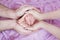 Hands of parents of dad and mom are holding in their hands the legs of a newborn baby