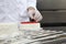 Hands pastry chef prepares a cake, cover with icing and decorate with strawberries, works on a stainless steel kitchen