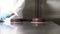 Hands pastry chef prepares a cake, cover pouring chocolate icing and decorate with flakes, working on a stainless steel industrial