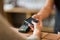 Hands with payment terminal and smartphone at bar