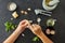 Hands peeling garlic with knife for pesto sauce