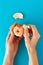 Hands peeling a mandarin orange, on blue background