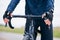 Hands of person, athlete and bicycle handlebar for training, triathlon sports and cardio fitness. Closeup, bike gear and