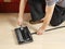 Hands of person clean the brushes of a mechanical sweeper on floor