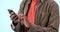 Hands, phone and man typing in studio isolated on blue background. Smartphone, closeup and person scroll on internet