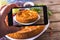 Hands with the phone takes pictures of a pie.Traditional homemade open pie with cabbage and sauerkraut on the plate on the rustic