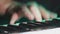 Hands of pianist or keyboardist of a rock band close up playing a synthesizer