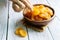 Hands picked up dried apricots in wooden bowl on wooden background, close up