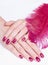 Hands with pink manicure and feather