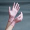 Hands in pink nitrile gloves on a gray background with a gradient