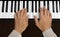 Hands playing a piano keyboard