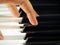 Hands playing piano keys closeup