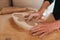 Hands of potter fill the form with a ceramic in the shape of a butterfly. Close up of hands