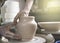 Hands of a potter on a pottery wheel close-up. Old traditional art, handmade, clay and ceramic production. Pottery workshop in