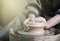 Hands of a potter on a pottery wheel close-up. Old traditional art, handmade, clay and ceramic production. Pottery workshop in