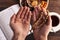 Hands of prayer with wooden rosary on background of book Koran, Cup tea, plate of dried fruits, iftar concept, month of Ramadan