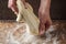 Hands prepare dough on a dark background