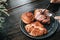 Hands prepare for eating fresh sweet bake croissant by use a fork and knife for cutting on a black plate for breakfast over in gar