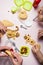 Hands prepare a holiday biscuit of snowmen, close-up. Multicolored baby dishes