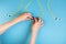 Hands prepare to tune a variable optic attenuator with a screwdriver. Blue background