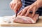 Hands preparing meat for roasting, butcher chef cook