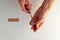 Hands prepping a shot with a vial and bandage against white background.