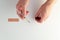 Hands prepping a shot with a vial and bandage against white background.