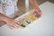 Hands of preschooler child girl playing educational games with wooden mathematical multicolored figures preparing for school in