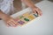 Hands of preschooler child girl playing educational games with wooden mathematical multicolored figures preparing for school in