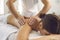 Hands of professional chiropractor or masseur making massage of back and shoulders for woman