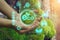 Hands protecting globe of plant on nature background ecology. ESG environmental social governance concept. Hand holding green