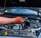 Hands in protective gloves with spanners against car engine