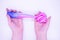 Hands pull out of transparent tube two-tone pink-and-blue slime