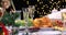 Hands putting roasted chicken on Christmas festive table closeup