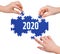 Hands with puzzle making 2020 word