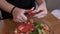 Hands of raw vegan woman slicing tomatoes for season salad healthy diet concept -