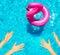 Hands reach inflatable flamingo swim in pool