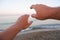 hands reaches for the sunset against the background of the sea