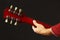 Hands of rock guitarist behind the guitar neck on dark background