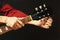 Hands of rock guitarist tunes the guitar on dark background