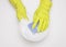Hands in rubber gloves close wash the plate with a sponge and foam. Dishwashing detergent, clean. White background.