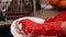 Hands in rubber gloves washing a plate with a sponge